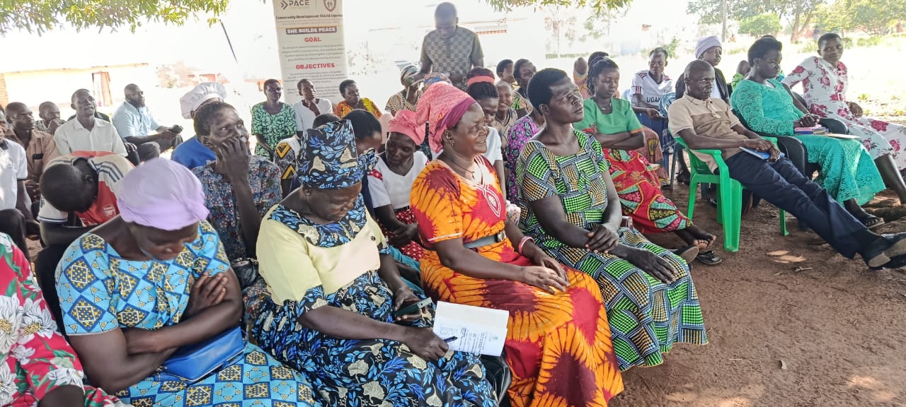 Community members seated outdoors at a discussion meeting