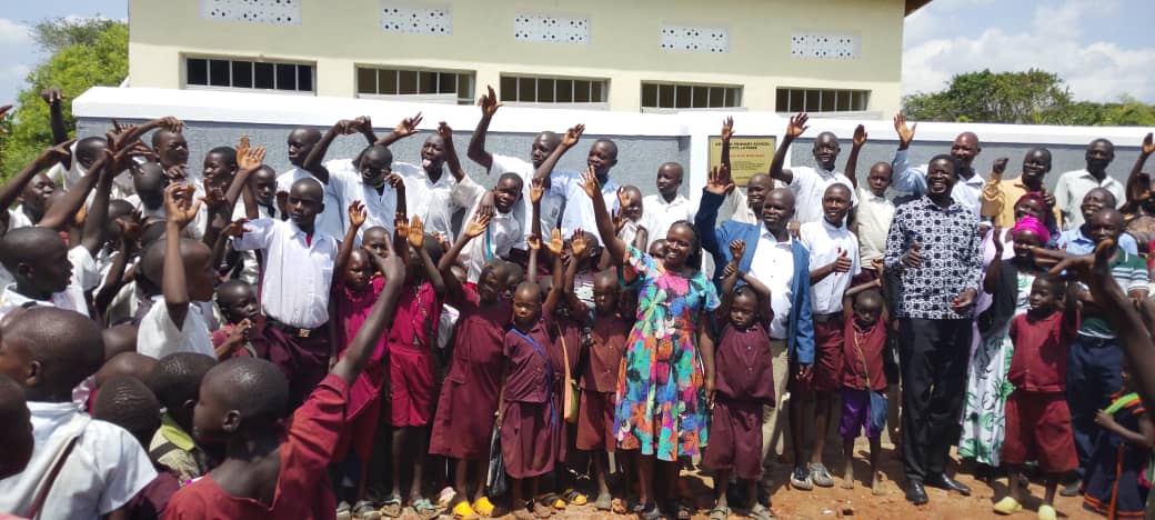 Pupils and community representatives gathered during a school sanitation facility handover in Uganda