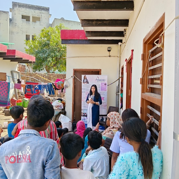 PRAMAN Foundation representative speaking to a group of women and children during a community outreach gathering