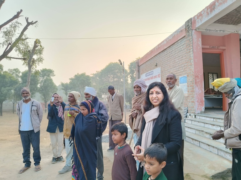 A community group gathered outdoors beside a school building